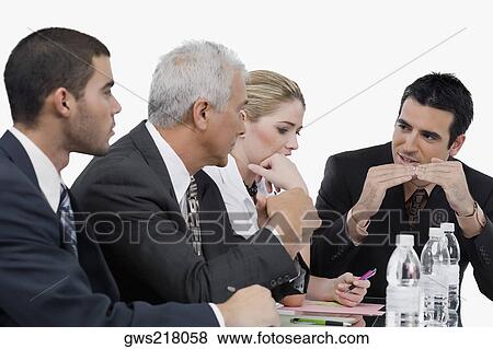 Three businessmen and a businesswoman at a meeting in a conference room View Large Photo Image Stock Photo - Three businessmen and a businesswoman at a meeting in a conference room. Fotosearch