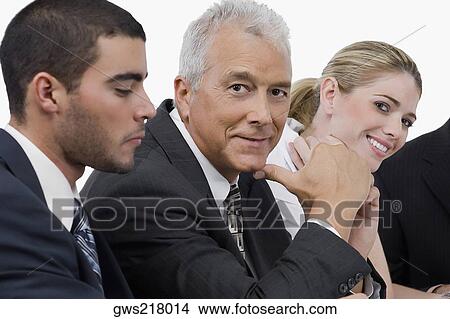 Picture - Two businessmen and a businesswoman at a meeting in a conference room. Fotosearch