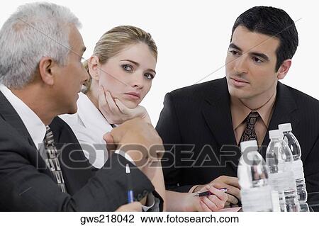 Two businessmen and a businesswoman at a meeting in a conference room View Large Photo Image Stock Image - Two businessmen and a businesswoman at a meeting in a conference room. Fotosearch