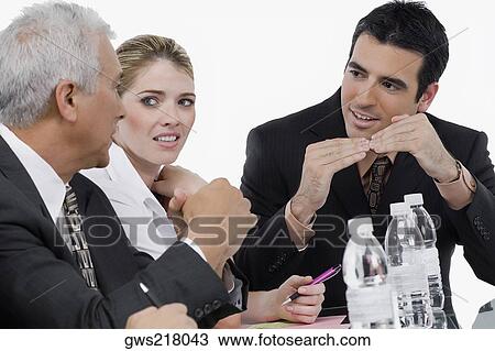 Two businessmen and a businesswoman at a meeting in a conference room View Large Photo Image Stock Image - Two businessmen and a businesswoman at a meeting in a conference room. Fotosearch