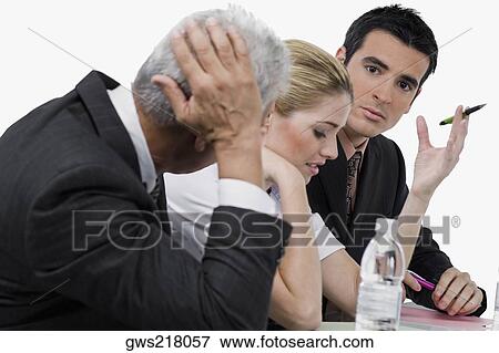 Two businessmen and a businesswoman at a meeting in a conference room View Large Photo Image Stock Photo - Two businessmen and a businesswoman at a meeting in a conference room. Fotosearch