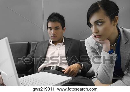 Businessman and a businessman looking at a laptop View Large Photo Image Stock Image - Businessman and a businessman looking at a laptop. Fotosearch