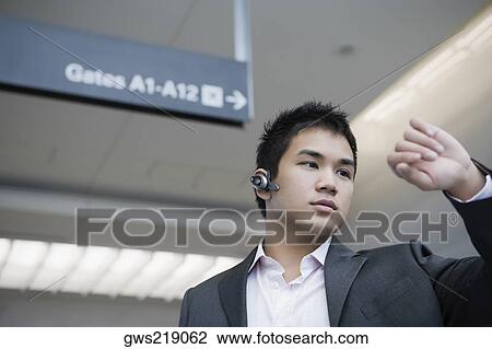 Businessman checking the time at an airport View Large Photo Image Stock Image - Businessman checking the time at an airport. Fotosearch
