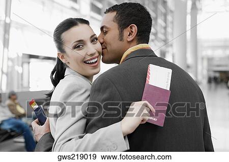 Close-up of a businessman kissing a businesswoman at an airport View Large Photo Image Stock Photo - Close-up of a businessman kissing a businesswoman at an airport. Fotosearch