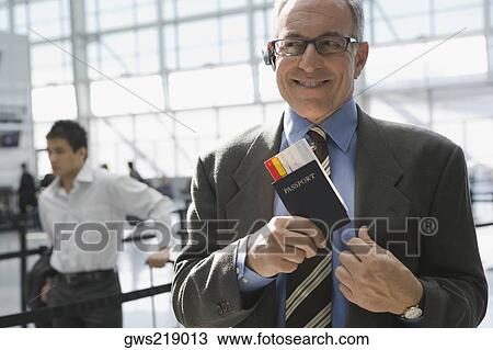 Close-up of a businessman putting a passport with an airplane ticket in his coat's pocket View Large Photo Image Stock Image - Close-up of a businessman putting a passport with an airplane ticket in his coat's pocket. Fotosearch