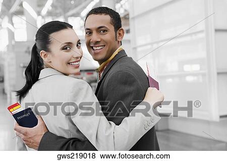 Stock Photo - Portrait of a businessman and a businesswoman with their arms around each other and smiling. Fotosearch