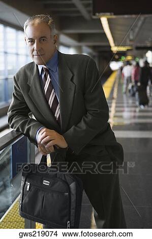 Portrait of a businessman holding a bag and standing at a subway station View Large Photo Image Picture - Portrait of a businessman holding a bag and standing at a subway station. Fotosearch
