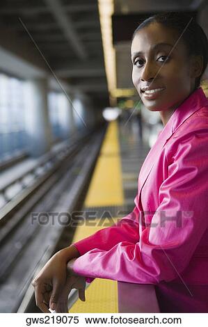 Stock Photography - Portrait of a businesswoman standing at a subway station and smiling. Fotosearch