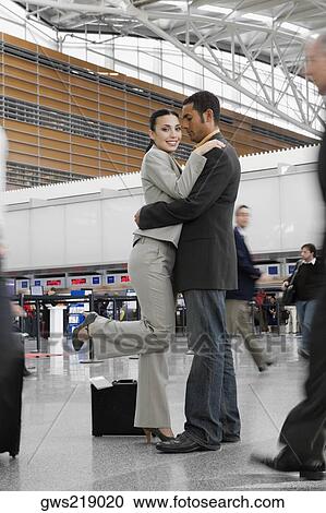 Side profile of a businessman and a businesswoman hugging each other at an airport View Large Photo Image Stock Image - Side profile of a businessman and a businesswoman hugging each other at an airport. Fotosearch
