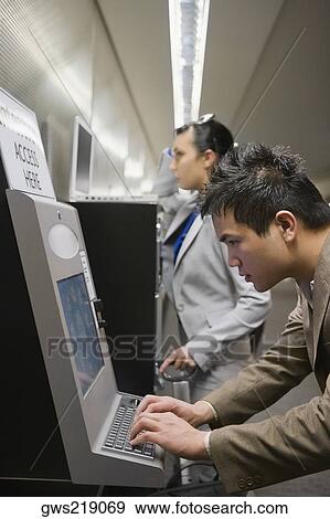 Stock Photo - Side profile of a businessman surfing the internet at an airport. Fotosearch