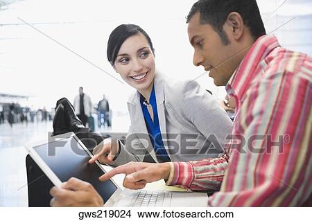 Picture - Side profile of a businessman with a businessman using a laptop. Fotosearch