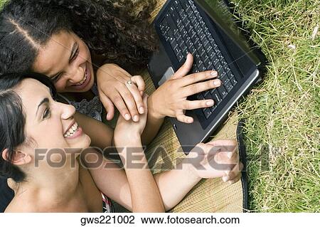 Close-up of female university students working on a laptop and smiling View Large Photo Image Stock Image - Close-up of female university students working on a laptop and smiling. Fotosearch