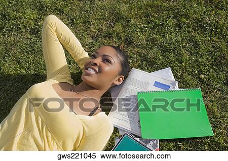High angle view of a young woman lying in a lawn and day dreaming View Large Photo Image Stock Photography - High angle view of a young woman lying in a lawn and day dreaming. Fotosearch