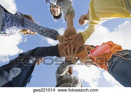 Low angle view of university students stacking their hands in a huddle View Large Photo Image Picture - Low angle view of university students stacking their hands in a huddle. Fotosearch
