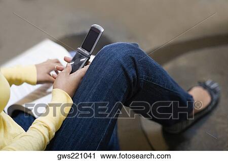 Low section view of a woman using a mobile phone View Large Photo Image Stock Image - Low section view of a woman using a mobile phone. Fotosearch