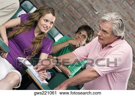 Professor assisting his students in a classroom View Large Photo Image Stock Image - Professor assisting his students in a classroom. Fotosearch