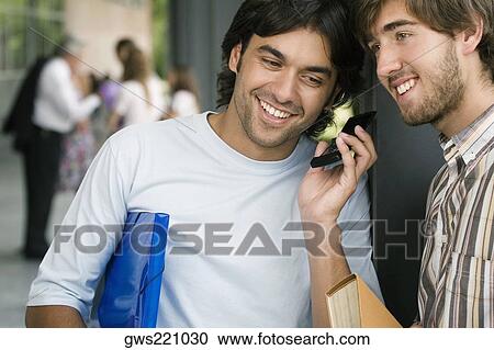Two male university students listening to a mobile phone View Large Photo Image Stock Image - Two male university students listening to a mobile phone. Fotosearch