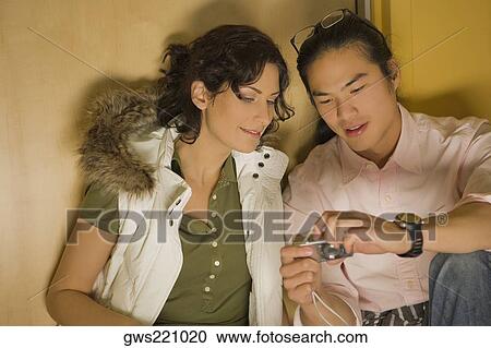 Stock Image - Young couple looking at a digital camera. Fotosearch