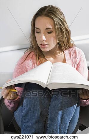 Young woman reading a book View Large Photo Image Stock Image - Young woman reading a book. Fotosearch
