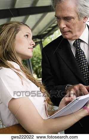 Close-up of a professor assisting his student in a corridor View Large Photo Image Stock Image - Close-up of a professor assisting his student in a corridor. Fotosearch