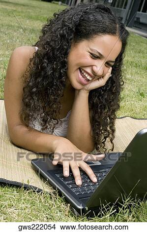 Close-up of a teenage girl working on a laptop and smiling View Large Photo Image Picture - Close-up of a teenage girl working on a laptop and smiling. Fotosearch
