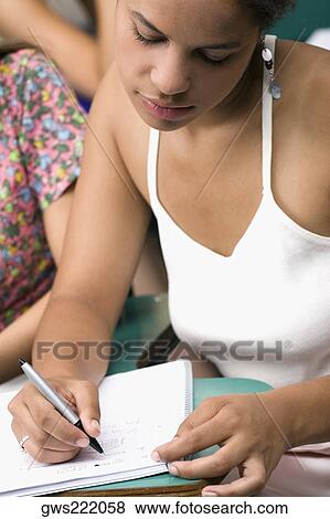 Close-up of a teenage girl writing with a pen in a notepad View Large Photo Image Stock Photo - Close-up of a teenage girl writing with a pen in a notepad. Fotosearch