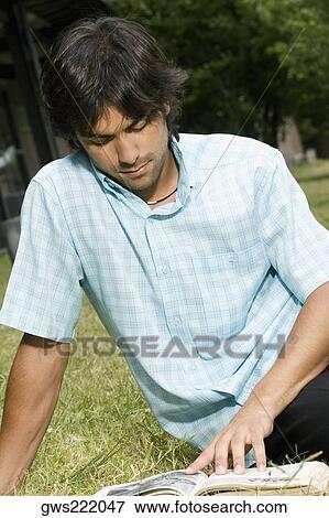 Close-up of a young man reading a book View Large Photo Image Stock Photo - Close-up of a young man reading a book. Fotosearch