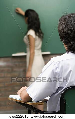 Female teacher teaching her student in a classroom View Large Photo Image Stock Image - Female teacher teaching her student in a classroom. Fotosearch
