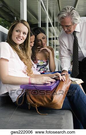 Male professor teaching his students in a corridor View Large Photo Image Stock Photograph - Male professor teaching his students in a corridor. Fotosearch