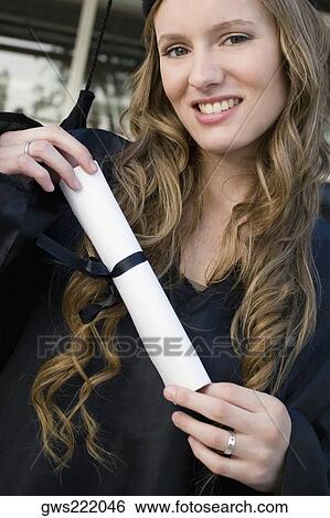 Portrait of a female graduate holding her degree View Large Photo Image Stock Photograph - Portrait of a female graduate holding her degree. Fotosearch