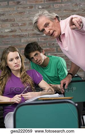 Professor assisting his students in a classroom View Large Photo Image Stock Photo - Professor assisting his students in a classroom. Fotosearch