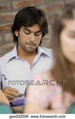 Two university students studying in a classroom View Large Photo Image Stock Photograph - Two university students studying in a classroom. Fotosearch