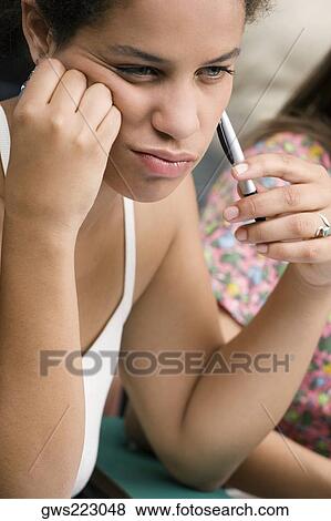 Close-up of a teenage girl holding a pen and thinking View Large Photo Image Stock Photo - Close-up of a teenage girl holding a pen and thinking. Fotosearch