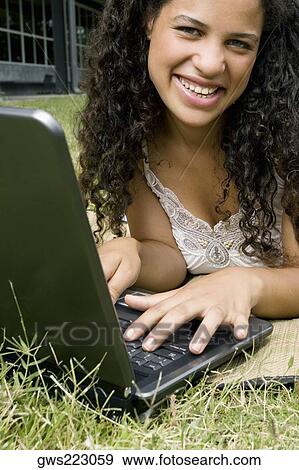 Portrait of a teenage girl working on a laptop and smiling View Large Photo Image Stock Photo - Portrait of a teenage girl working on a laptop and smiling. Fotosearch