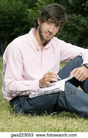 Portrait of a young man writing with a pen on a notepad View Large Photo Image Stock Image - Portrait of a young man writing with a pen on a notepad. Fotosearch