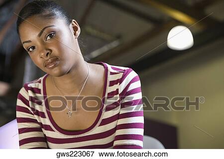 Stock Photo - Portrait of a young woman looking serious. Fotosearch