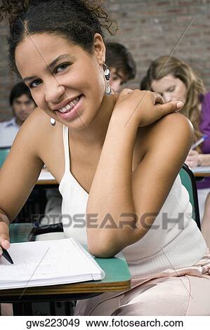 Portrait of a young woman studying in a classroom View Large Photo Image Stock Photo - Portrait of a young woman studying in a classroom. Fotosearch