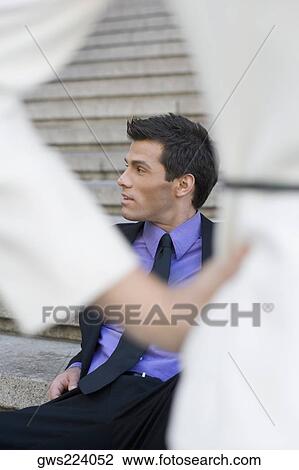 Businessman sitting on steps and looking away View Large Photo Image Stock Image - Businessman sitting on steps and looking away. Fotosearch
