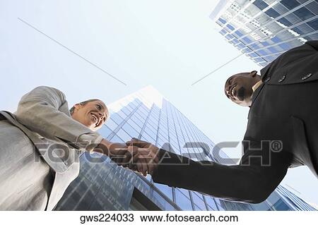 Low angle view of a businessman and a businesswoman shaking hands View Large Photo Image Stock Image - Low angle view of a businessman and a businesswoman shaking hands. Fotosearch