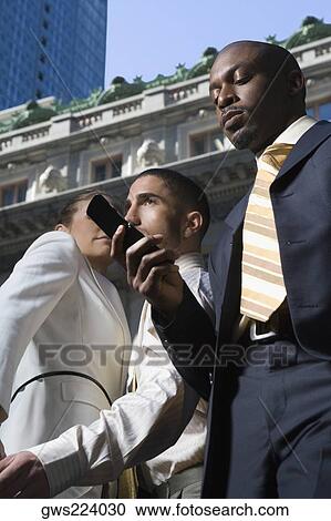 Low angle view of a businessman using a mobile phone View Large Photo Image Stock Image - Low angle view of a businessman using a mobile phone. Fotosearch