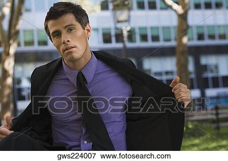 Portrait of a businessman putting off his coat View Large Photo Image Stock Photo - Portrait of a businessman putting off his coat. Fotosearch