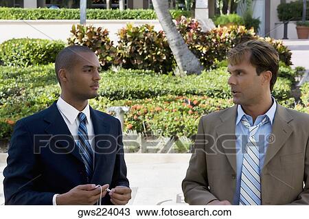 Two businessmen talking to each other View Large Photo Image Stock Image - Two businessmen talking to each other. Fotosearch