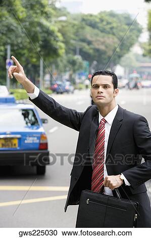 Businessman hailing for a vehicle View Large Photo Image Stock Image - Businessman hailing for a vehicle. Fotosearch
