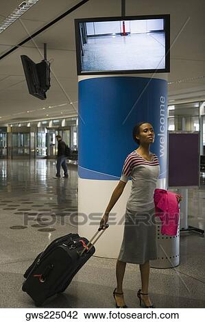 Businesswoman pulling her luggage at an airport View Large Photo Image Stock Image - Businesswoman pulling her luggage at an airport. Fotosearch