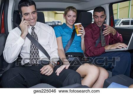 Close-up of a businesswoman sitting between two businessmen in a car and smiling View Large Photo Image Stock Photograph - Close-up of a businesswoman sitting between two businessmen in a car and smiling. Fotosearch