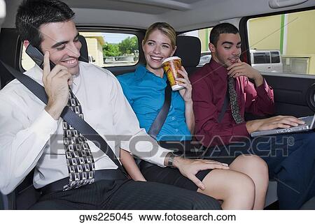 Close-up of a businesswoman sitting between two businessmen in a car and smiling View Large Photo Image Stock Photography - Close-up of a businesswoman sitting between two businessmen in a car and smiling. Fotosearch