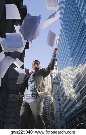 Low angle view of a businessman throwing sheet of papers in air View Large Photo Image Stock Image - Low angle view of a businessman throwing sheet of papers in air. Fotosearch