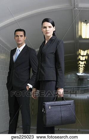 Portrait of a businesswoman carrying a briefcase with a businessman standing behind her View Large Photo Image Stock Image - Portrait of a businesswoman carrying a briefcase with a businessman standing behind her. Fotosearch