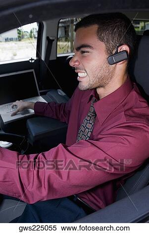 Side profile of a businessman sitting in a car and clenching his teeth View Large Photo Image Stock Photography - Side profile of a businessman sitting in a car and clenching his teeth. Fotosearch
