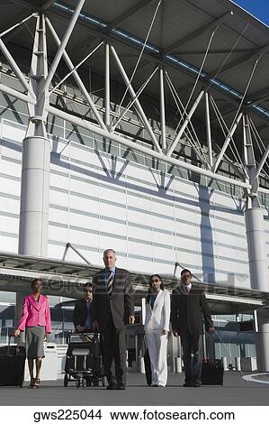 Three businessmen with two businesswomen outside at an airport View Large Photo Image Picture - Three businessmen with two businesswomen outside at an airport. Fotosearch